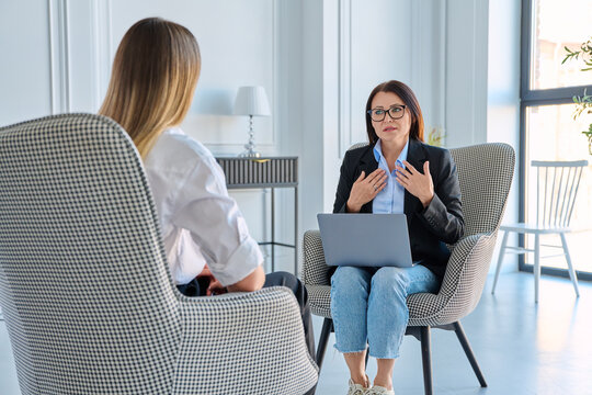 Female recruiter interviewing applicant with laptop in modern office space