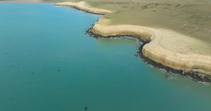 4K video; Aerial view of the layered cliff coast in the vicinity of the city of Puerto San Julian, Argentina; Slow panning drone shot