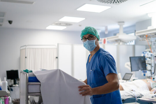 Medical professional wearing scrubs and mask in hospital icu