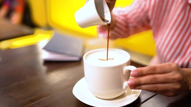 Creamy coffee latte with foam next to a small cup of espresso on a dark table