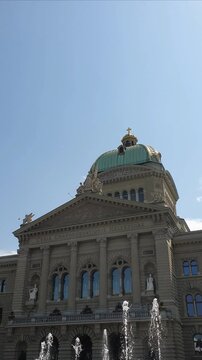 Low angle view of the Swiss parliament federal palace facade with water jets in foreground.