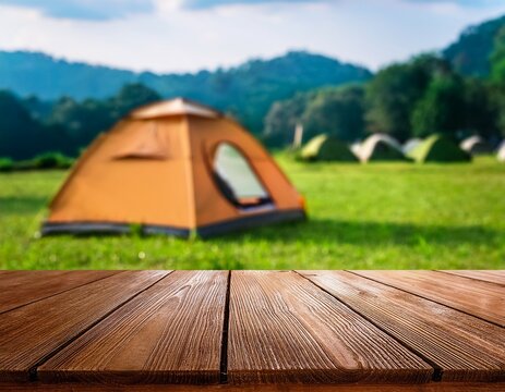 wooden table in blur camping tent and grass field cool and relaxing concept for product display montage or key visual layout design space for text