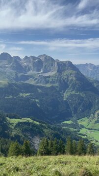 Panoramic vew of the Swiss Alps with green mountain ridge and blue sky, Switzerland