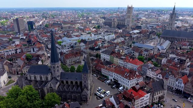 Aerial view video clip of historic Ghent city center in Belgium featuring Saint Nicholas' Church, Belfry tower, Saint Bavo Cathedral, and red roofed medieval architecture on a sunny day
