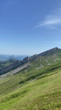 Panoramic vew of the Swiss Alps with green mountain ridge and blue sky, Switzerland