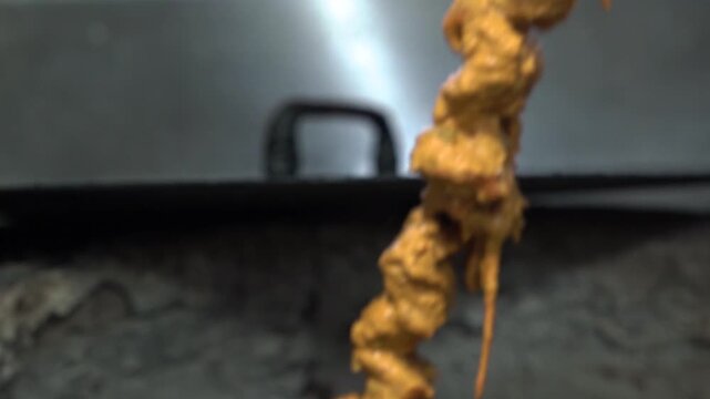 Close up of chef preparing spicy marinated chicken tikka on skewers for authentic tandoor cooking at an Indian restaurant.