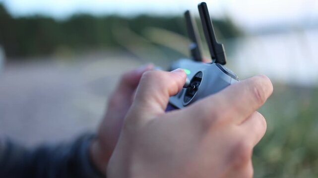 Close up of a drone remote controller with fingers smoothly operating the joysticks showcasing professional piloting and advanced drone technology