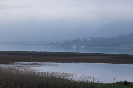 delicate fog hovering below Klein Mountains and lagoon, Stanford, South Africa
