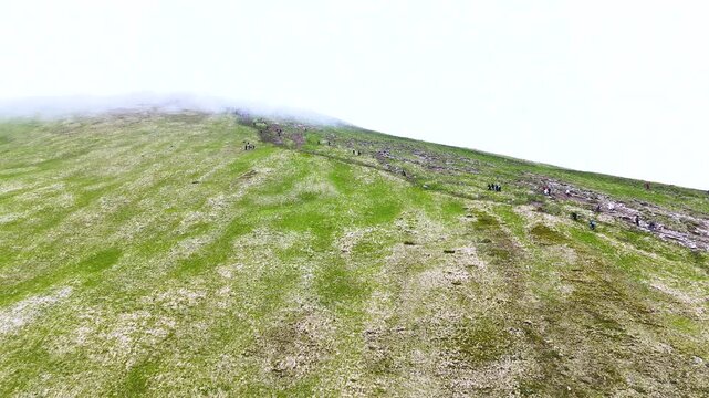 Mass ascent of tourists to Goverla mountain, the highest peak of the Ukrainian Carpathians. Soil erosion around the trail on the mountain slope is a consequence of mass tourism. Concept of travel.