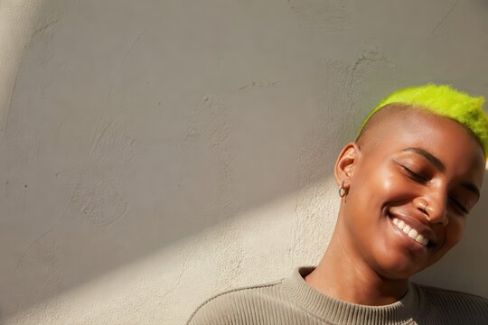 Smiling portrait with neon green hair and warm wall light