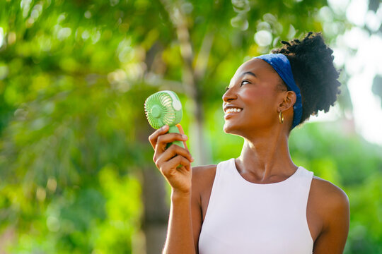African female enjoying fresh air with portable fan