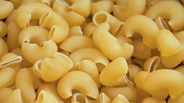 Dry Elbow Macaroni Pasta Falling into a Black Cooking Pot