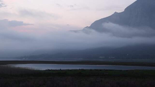 delicate fog hovering below Klein Mountains and lagoon and country road, Stanford, South Africa