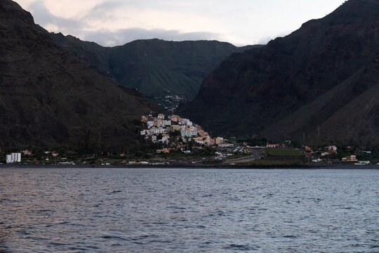 Whitewashed houses of La Calera stacked up the rock spur in the Valle Gran Rey gorge on La Gomera seen from the sea on an overcast morning
