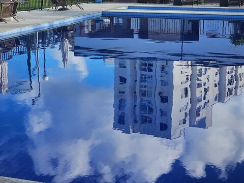 Reflection of Buildings and Clouds in the Water of a Residential Swimming Pool in a Gated Community
