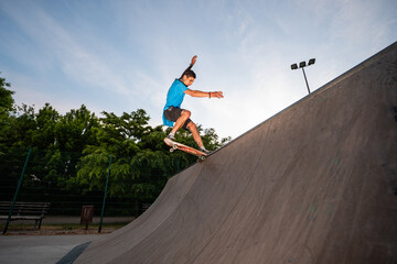 Skateboarder grinding on a skatepark ramp at sunset © Zoran Jesic