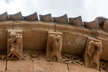 Carved stone corbels and metopes depicting human figures and floral motifs under the eaves at the 13th-century Romanesque Church of Natividad de Nuestra Senora in Sotillo, Segovia, Spain © Nandi Estévez