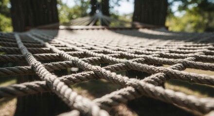 Fototapeta premium Relaxing Hammock Netting Suspended Between Majestic Trees In A Sunny Forest
