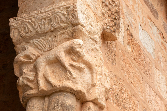 Carved Romanesque stone capital depicting a quadruped animal figure in the porticoed gallery of the Church of San Gines, an 11th-century Romanesque temple in Rejas de San Esteban, Soria, Spain