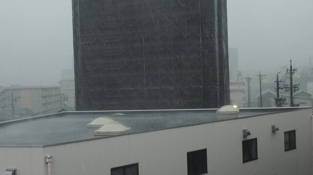 夏のゲリラ雷雨の様子と都市の住宅地のメンテナンス中のマンションの様子