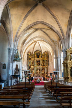 Gothic-Renaissance interior of Iglesia de San Pedro Ap&oacute;stol featuring ribbed vaulting, central aisle with wooden pews & gilded altarpiece in Santa Gadea del Cid (Burgos, Spain)