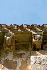 Sculpted Romanesque corbels featuring an animal head and a human figure under the eaves of the Church of Inmaculada Concepcion, 12th century, Crespos, Valle de Manzanedo, Burgos, Spain © Nandi Estévez