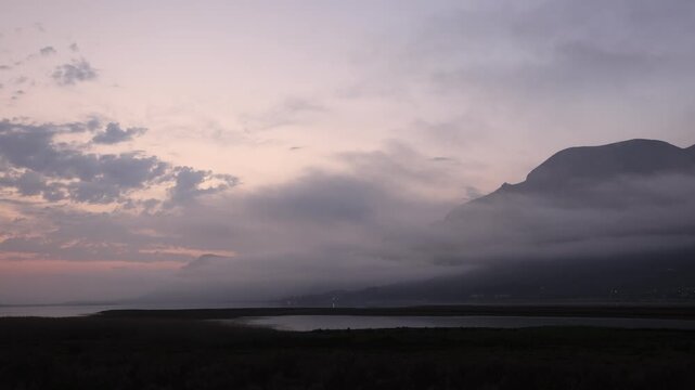 delicate fog hovering below Klein Mountains and lagoon and country road, Stanford, South Africa