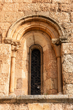 Detail of the apsidal window with splayed semi-circular arch, archivolts, and carved capitals on the Church of San Lorenzo in Zorita del Paramo, Palencia, Castilla y Leon, Spain, late Romanesque
