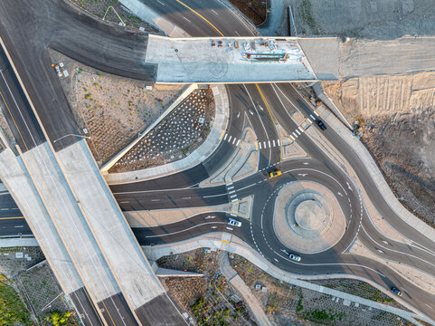 Aerial view of Interurban South Trailhead roundabout and highway overpass construction with road markings and vehicles in Fife, Washington, United States.