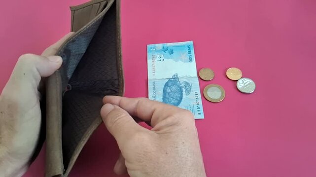 Empty leather wallet showing scarcity with brazilian currency video animation