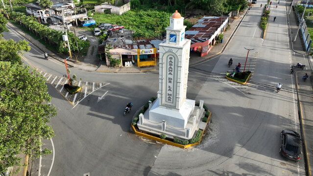 Aerial view of the Sabana de la Mar monument standing at a road intersection with surrounding streets, buildings, and sparse traffic in Sabana de la Mar, Hato Mayor Province, Dominican Republic.