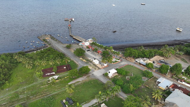 Aerial view of the pier with small boats in the bay, lush greenery, and coastal infrastructure in Sabana de la Mar, Hato Mayor Province, Dominican Republic.