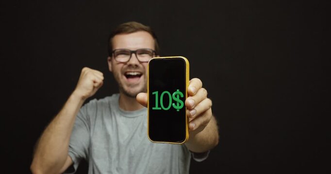 Businessman celebrating as earnings continuously increase on a smartphone screen. Ideal for profit, passive income, investing, online business, and financial success concepts.