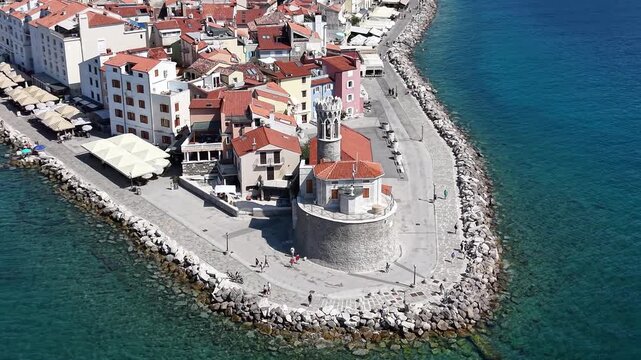 Drone view of Church of St Clement and lighthouse in Piran, Slovenia