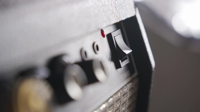 Turning On Guitar Amplifier Symbolizing the Start of a Music Performance
