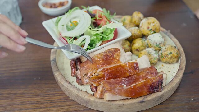 Peruvian roasted pork with crispy skin served with native potatoes 