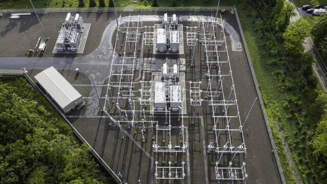 Aerial view of an electrical substation featuring high-voltage power transformers, busbars, circuit breakers, and steel support structures in Dover Plains, New York, United States.