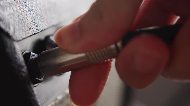 Plugging Guitar Cable into Amplifier Before Live Music Performance