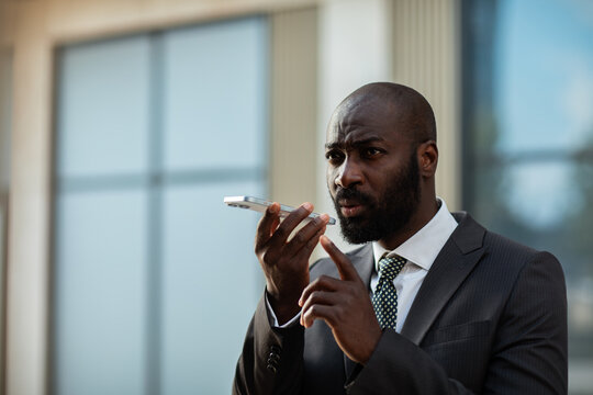 Business professional using voice assistant outside office