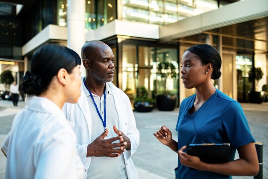 Doctors and nurse discussing treatment outside hospital