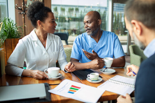 Medical team meeting over coffee in hospital cafeteria