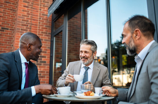 Business colleagues meeting for coffee at outdoor cafe
