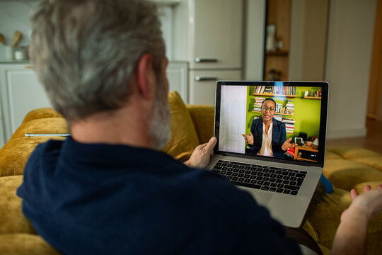 Mature man on sofa having video call at home