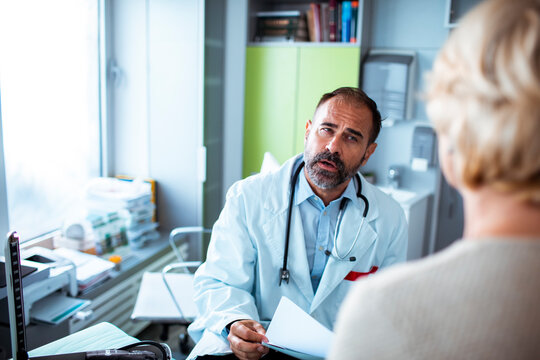 Male doctor consulting senior patient in clinic