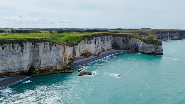 White chalk cliffs of Normandy with erosion features on French coast. Aerial landscape of limestone coastline and natural formations