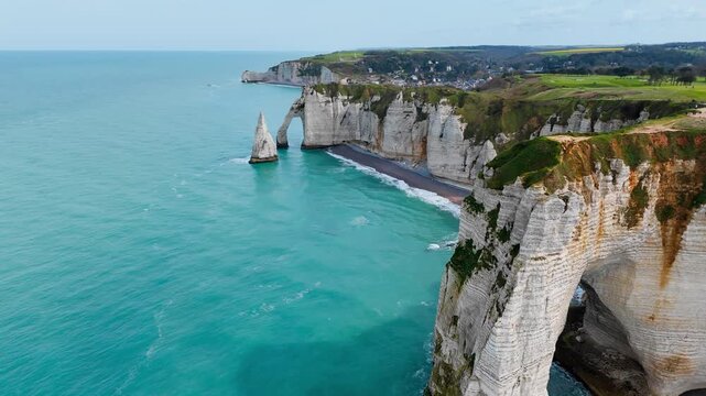 Etretat cliffs with sea arch and rock needle along Normandy shore, France. Aerial coastal landscape with famous natural landmark
