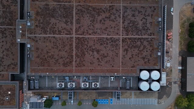 Aerial view of the green roof of Iron Mountain Data Centers FRA-2, featuring HVAC units and large white storage tanks in Frankfurt am Main, Hessen, Germany.