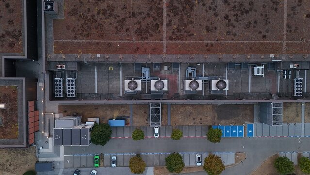 Aerial view of Iron Mountain Data Centers FRA-2 featuring rooftop HVAC units, green roof sections, and a parking lot with cars in Frankfurt am Main, Hessen, Germany.