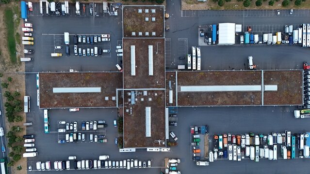 Aerial view of Iron Mountain Data Centers FRA-2 with green roofs and surrounding parking lots filled with trucks and vans in Frankfurt am Main, Hessen, Germany.