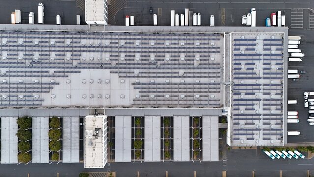 Aerial view of Iron Mountain Data Centers FRA-2 featuring an industrial building with rooftop solar panels, loading docks, and green spaces in Frankfurt am Main, Hessen, Germany.